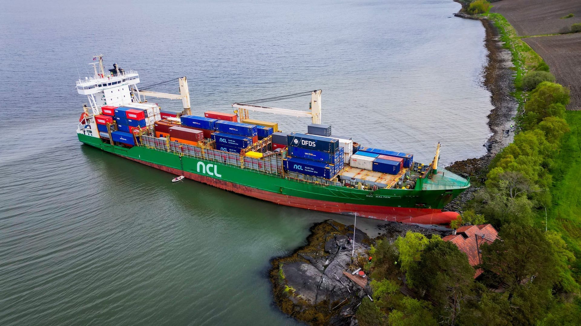 Norwegen Containerschiff nahe eines Hauses am Trondheimfjord